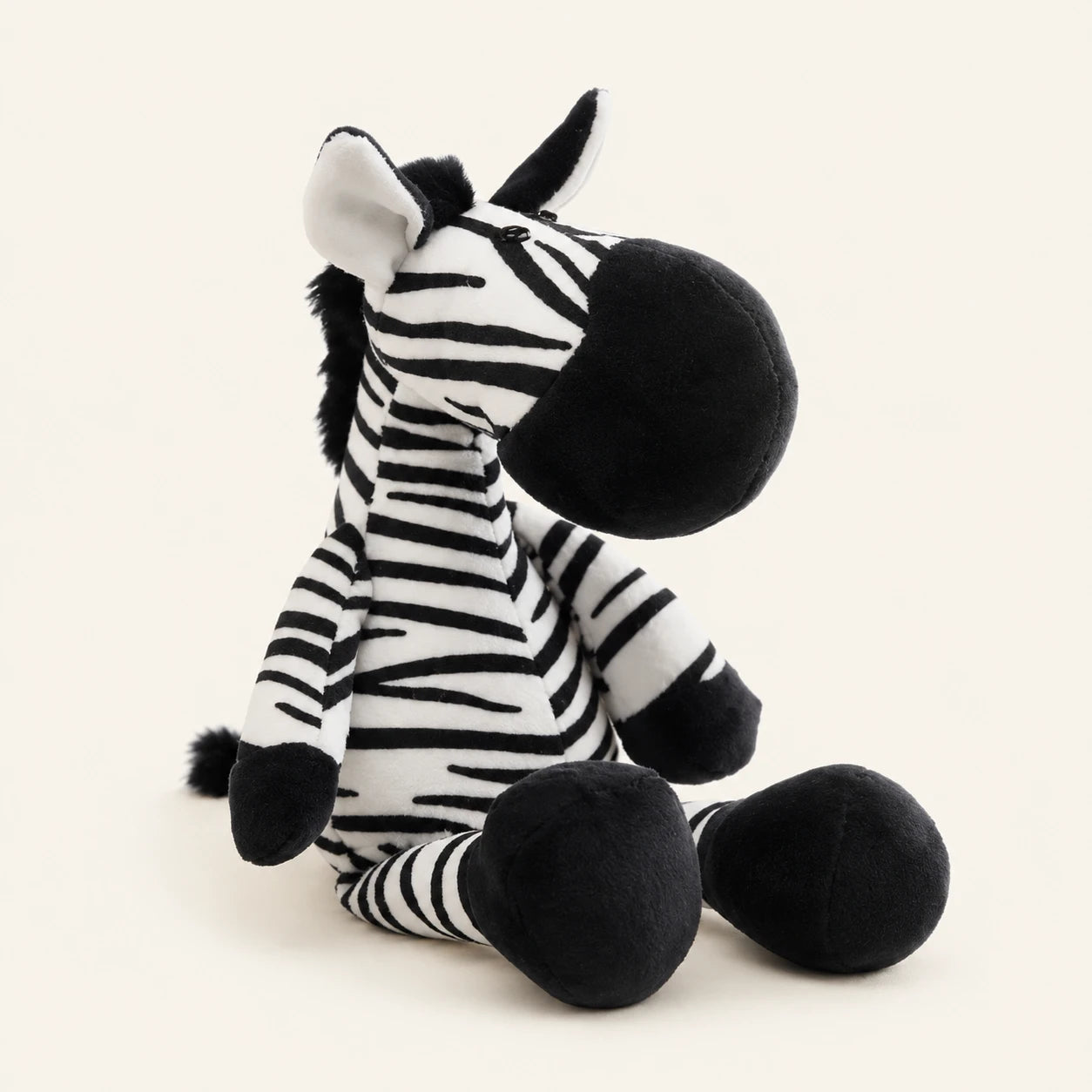 Peluche zèbre réaliste assise, fond beige ivoire
