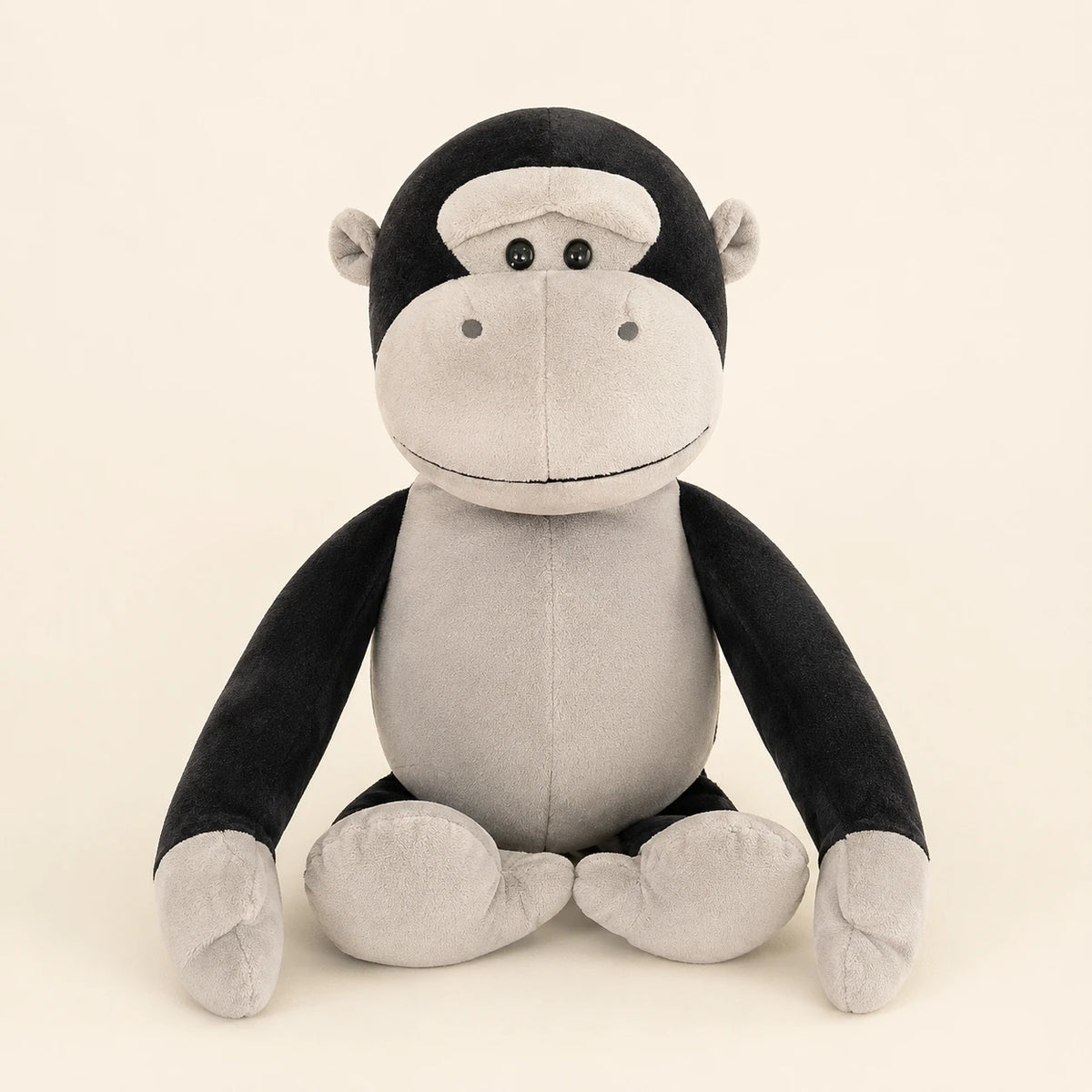 Peluche gorille noire et grise assise, vue principale sur fond ivoire