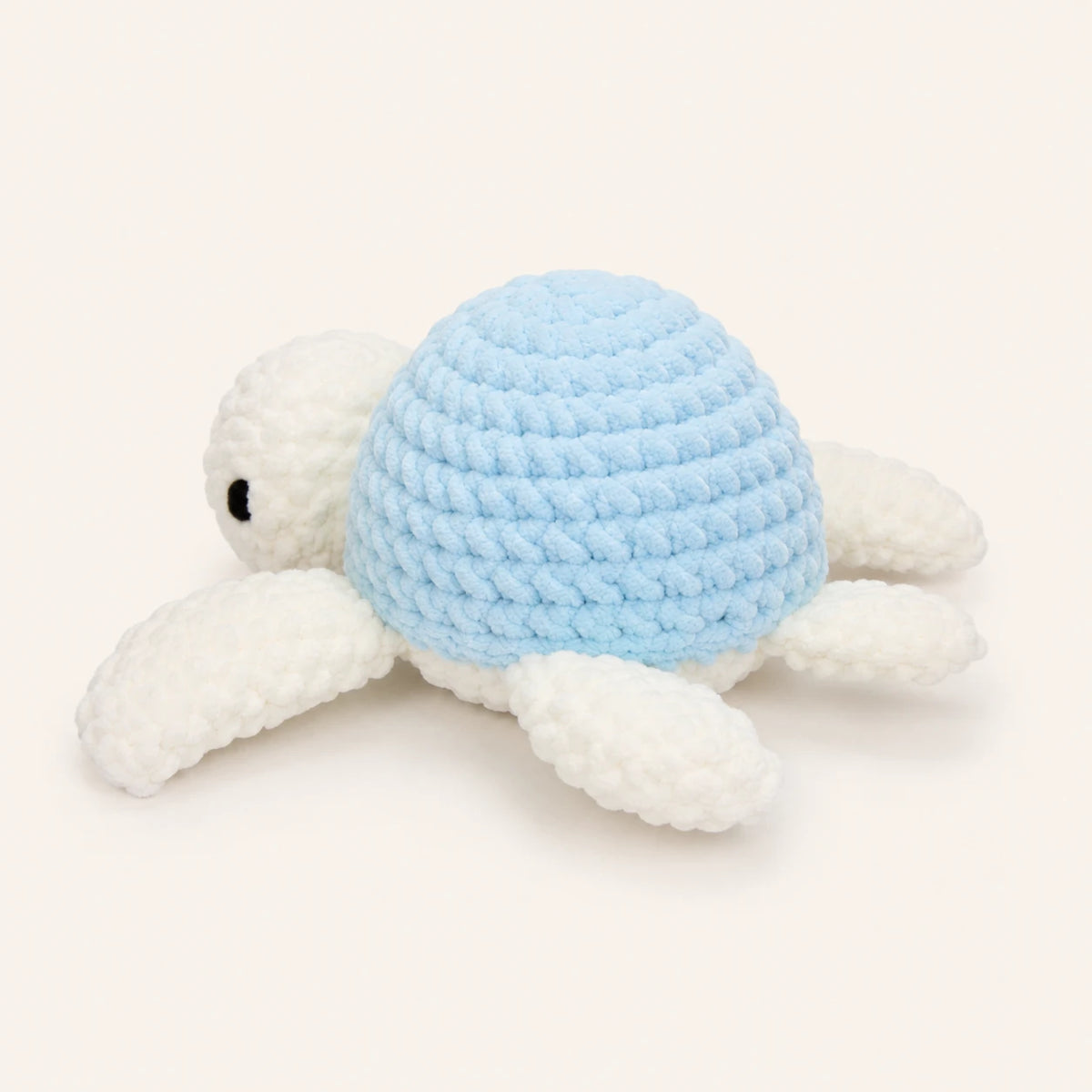 Peluche tortue au crochet bleue, vue de trois-quarts, fond ivoire