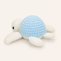 Peluche tortue au crochet bleue, vue de trois-quarts, fond ivoire