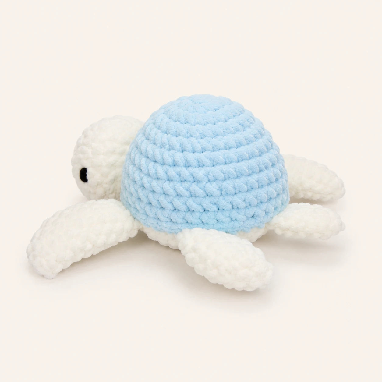 Peluche tortue au crochet bleue, vue de trois-quarts, fond ivoire