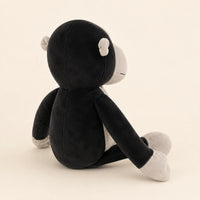 Peluche gorille noire et grise vue de profil sur fond ivoire