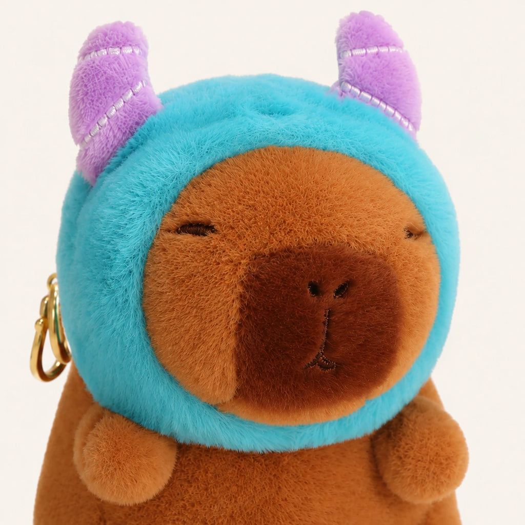 Gros plan sur le visage de la peluche capybara au bonnet bleu
