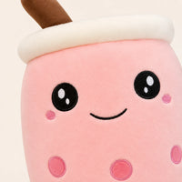 Gros plan sur le visage brodé de la peluche bubble tea rose