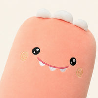 Gros plan sur le visage brode du coussin peluche dinosaure rose