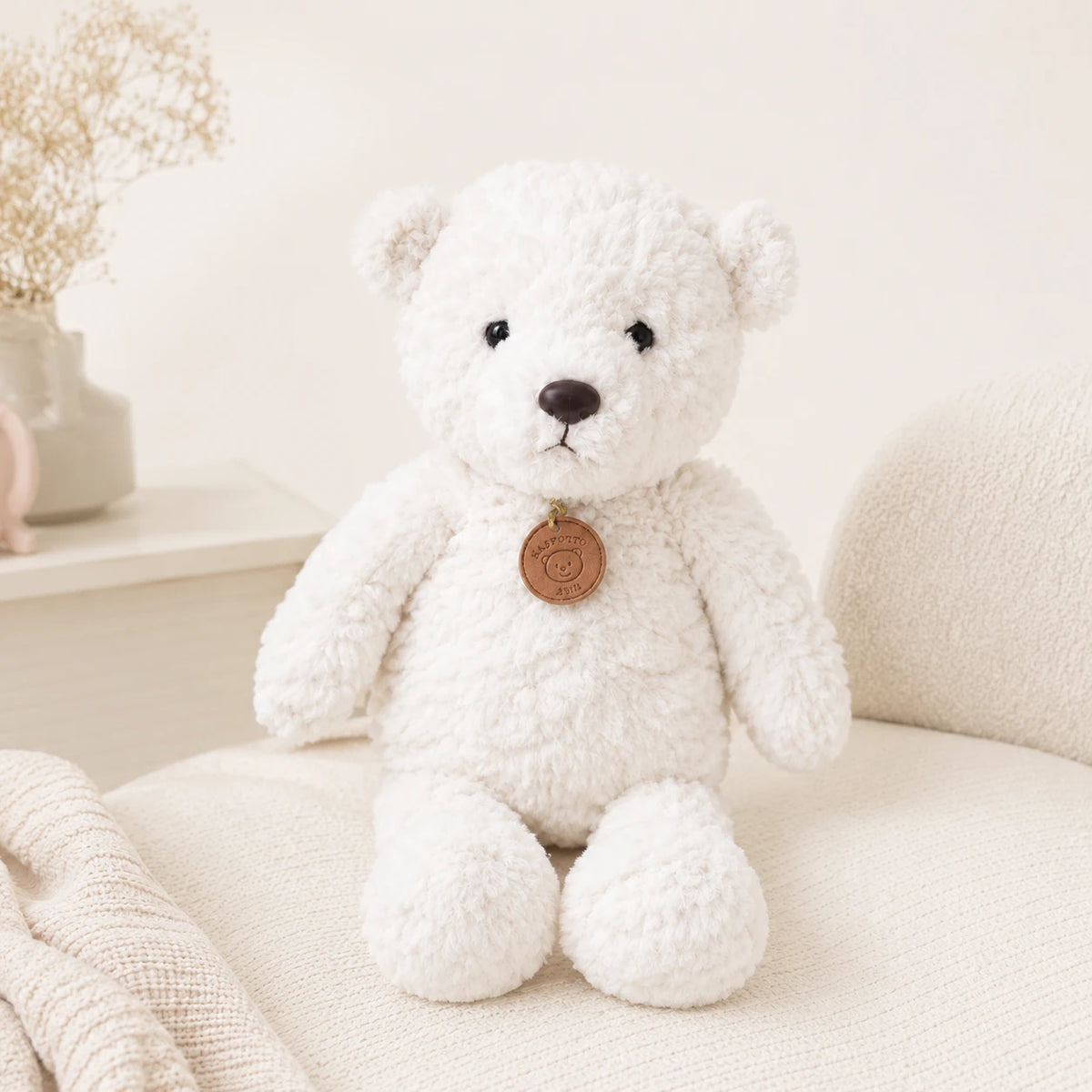 Peluche ours blanc longues pattes 50 cm installée dans un fauteuil
