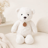 Peluche ours blanc longues pattes 50 cm installée dans un fauteuil