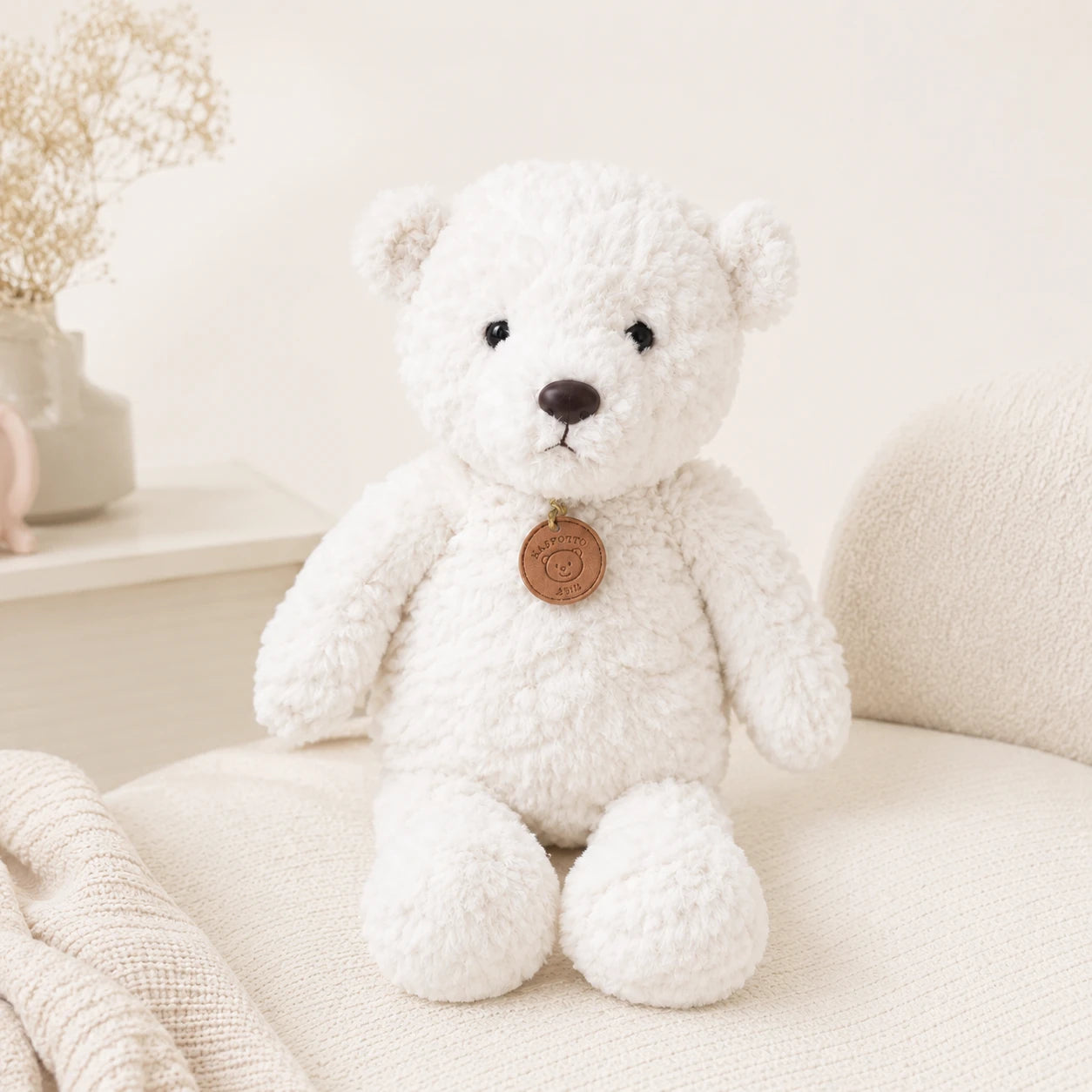 Peluche ours blanc longues pattes 50 cm installée dans un fauteuil