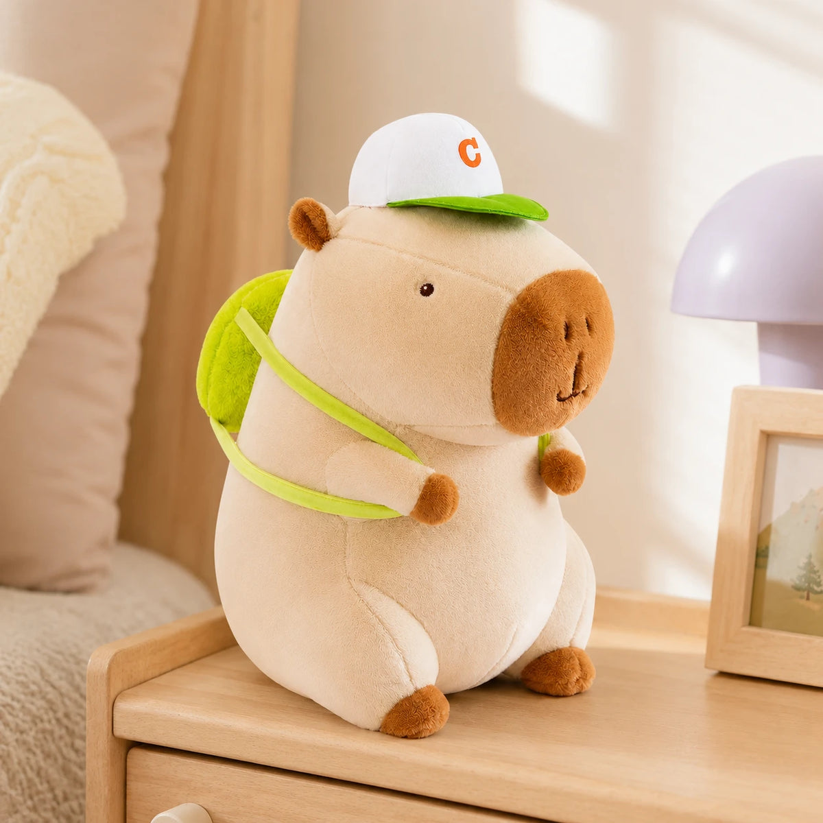 Peluche capybara creme posee sur une table de chevet, mise en situation