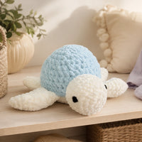 Peluche tortue au crochet bleue en situation dans un intérieur cosy