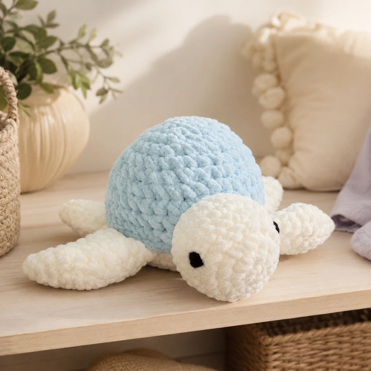 Peluche tortue au crochet bleue en situation dans un intérieur cosy