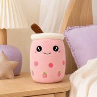 Peluche bubble tea rose posée sur une étagère dans une chambre douce
