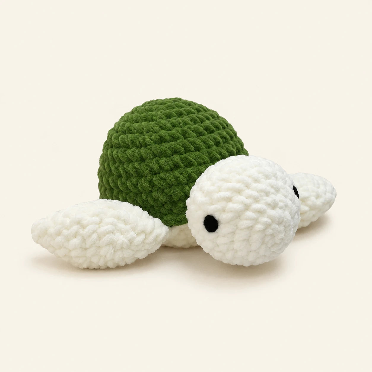 Peluche tortue au crochet, carapace verte, vue de face, environ 30 cm, fond ivoire