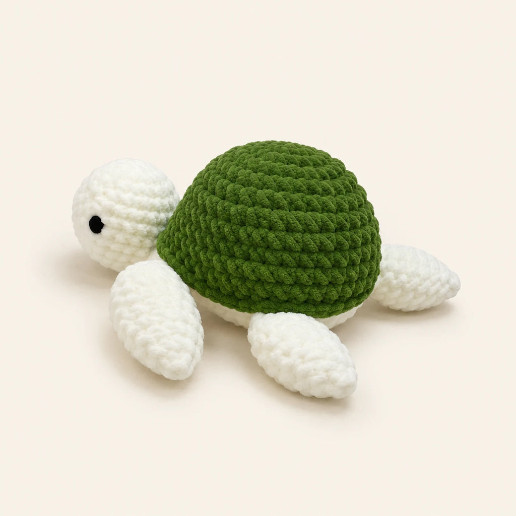 Peluche tortue au crochet verte, vue de trois-quarts, fond ivoire