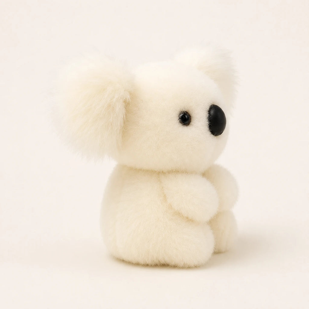 Peluche koala blanche vue de trois-quarts sur fond ivoire