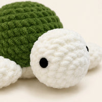 Peluche tortue au crochet verte, gros plan sur la maille