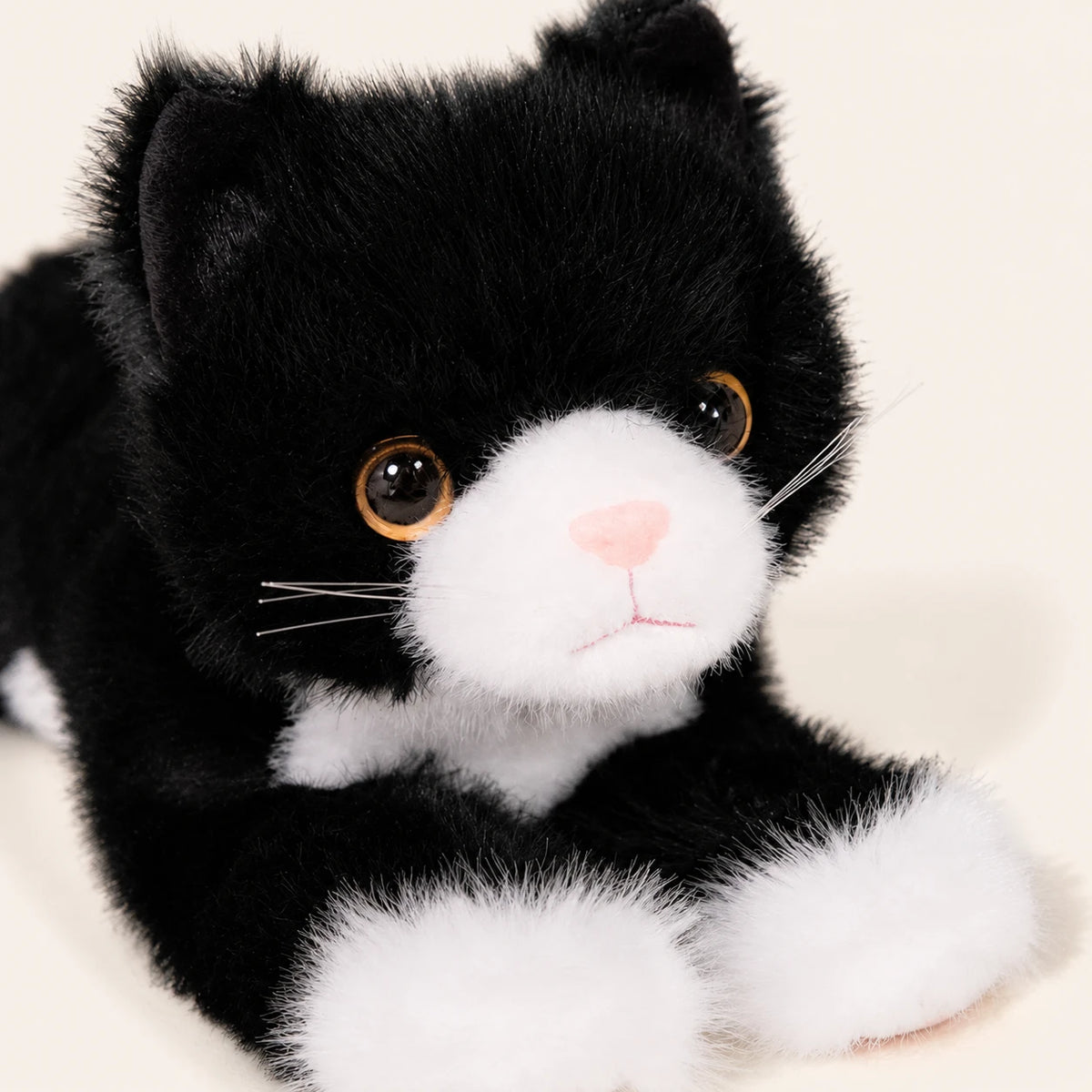 Peluche chat realiste noir et blanc, gros plan detail du visage