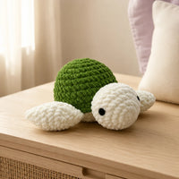 Peluche tortue au crochet verte en situation dans un intérieur cosy