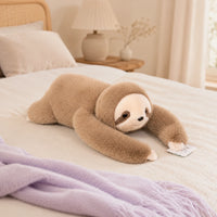 Peluche paresseux beige allongée sur un lit douillet