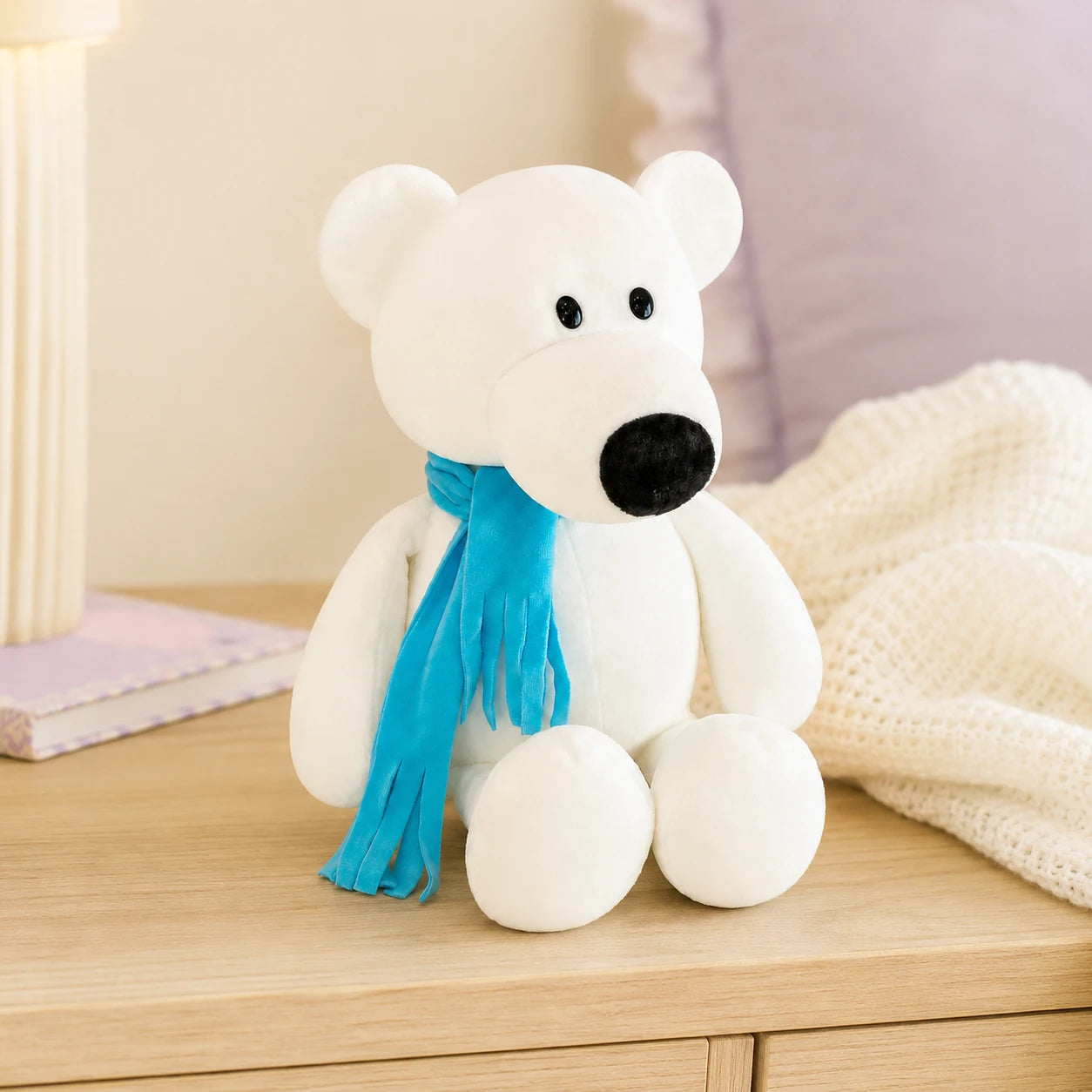 Peluche ours polaire posée sur une commode dans une chambre douce