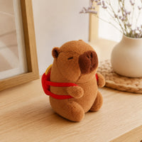 Peluche capybara posée sur une table en bois, mise en situation