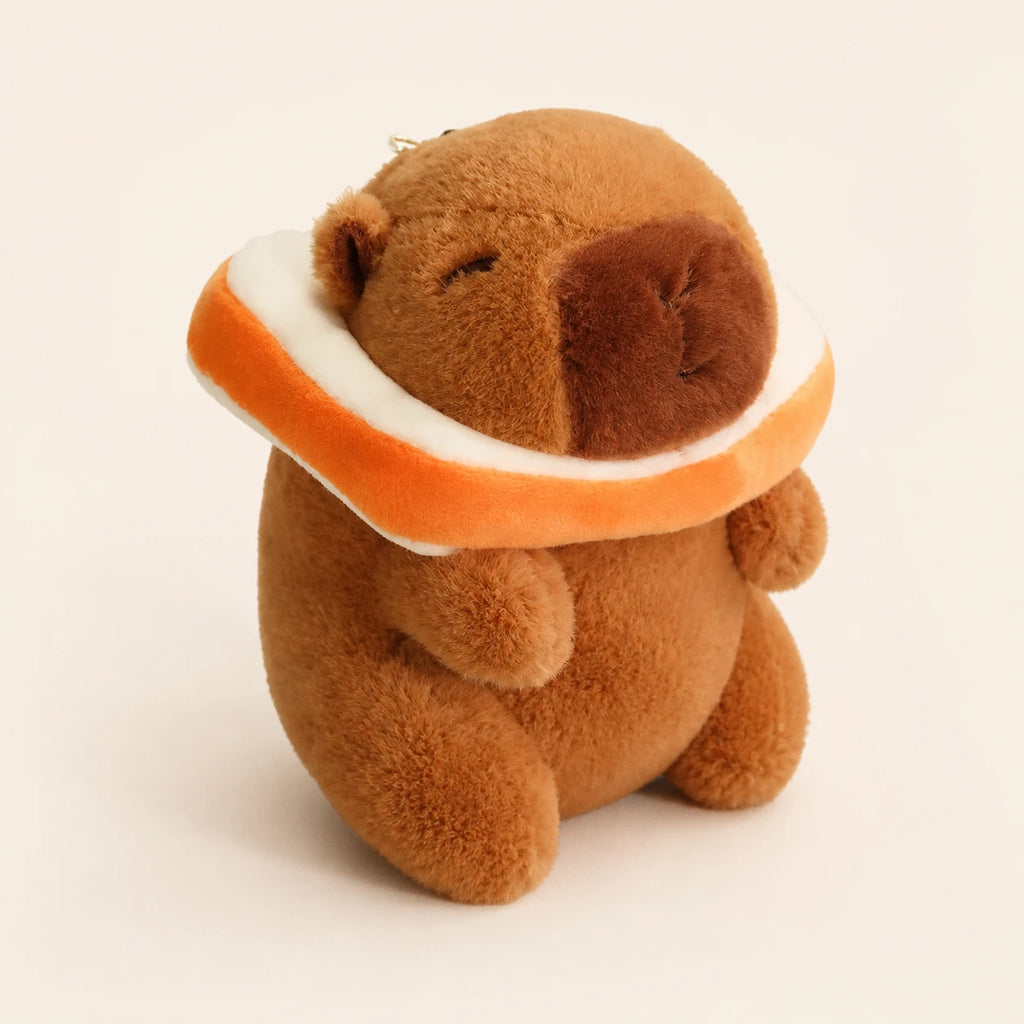 Peluche capybara vue de trois-quarts, fond ivoire
