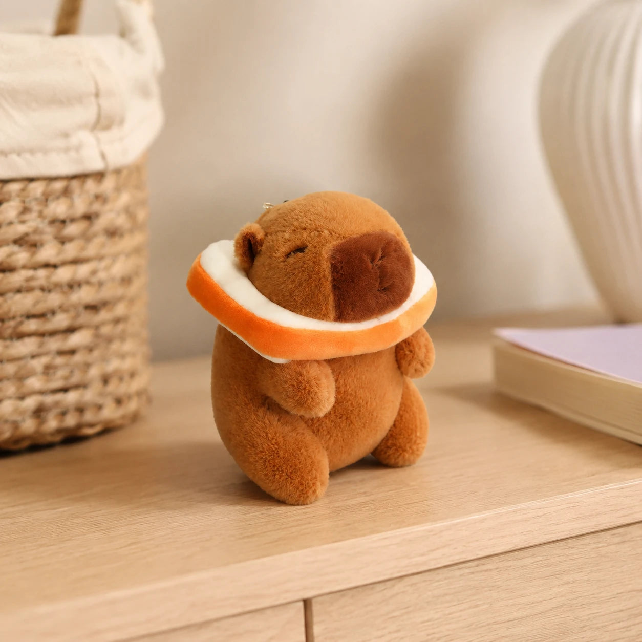 Peluche capybara posée près d'un panier, mise en situation