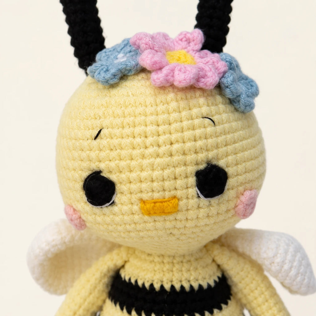 Gros plan sur le visage et la maille de la peluche abeille