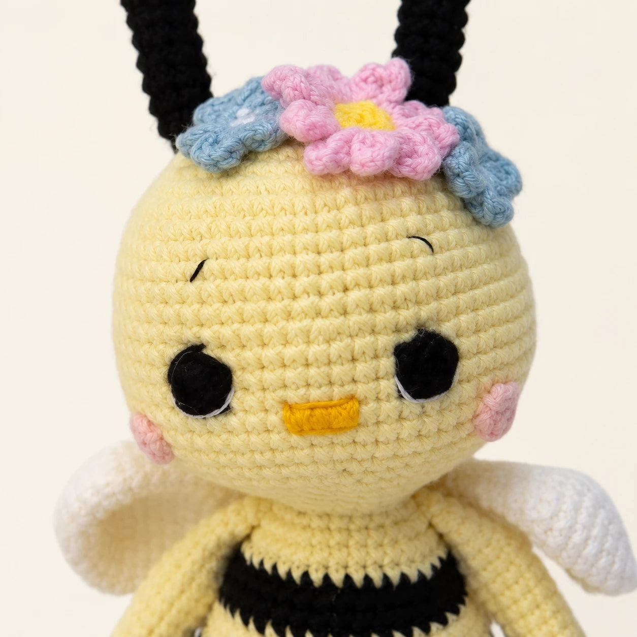 Gros plan sur le visage et la maille de la peluche abeille