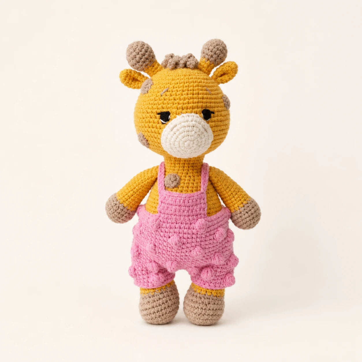 Peluche girafe au crochet salopette rose vue de face
