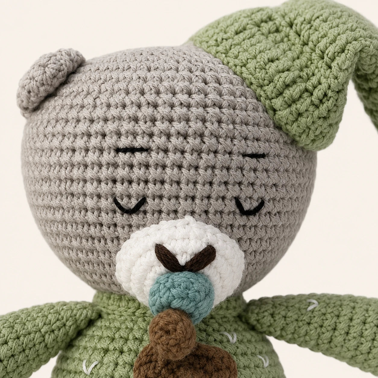 Gros plan sur le visage et la texture crochetee de la peluche ourson