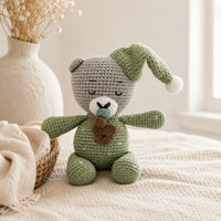 Peluche amigurumi ourson endormi en situation dans un interieur chaleureux