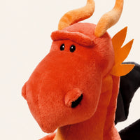 Gros plan sur le visage et la texture de la peluche dragon orange