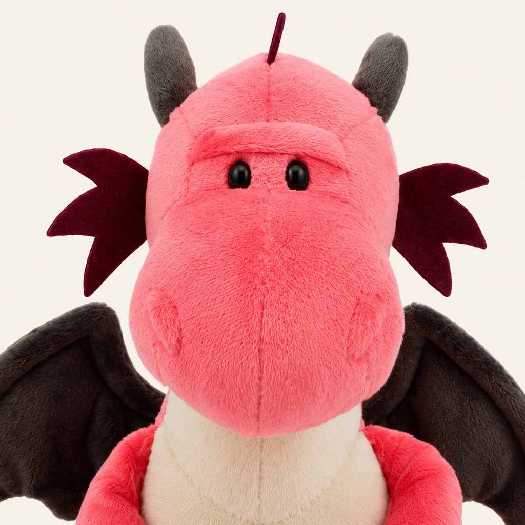 Gros plan sur le visage et la texture de la peluche dragon rose