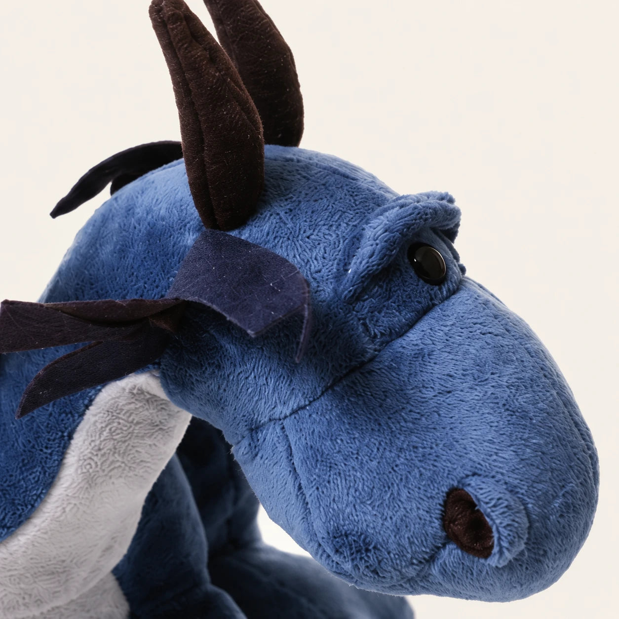 Detail du visage et de la texture de la peluche dragon bleu