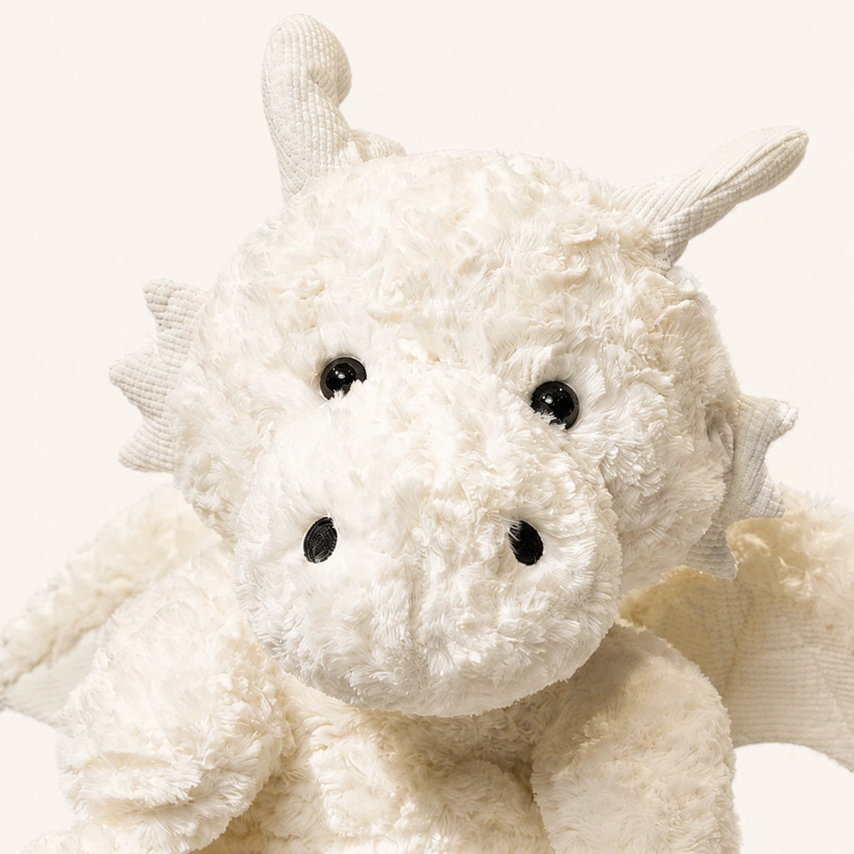 Detail du visage et de la texture de la peluche dragon blanc