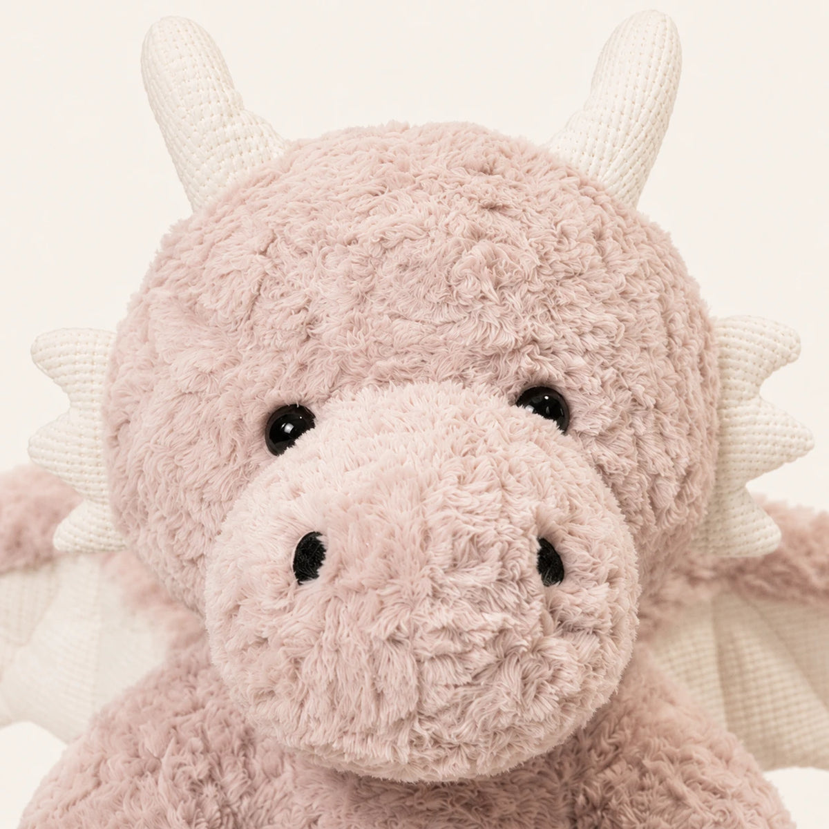 Detail du visage et de la texture de la peluche dragon rose