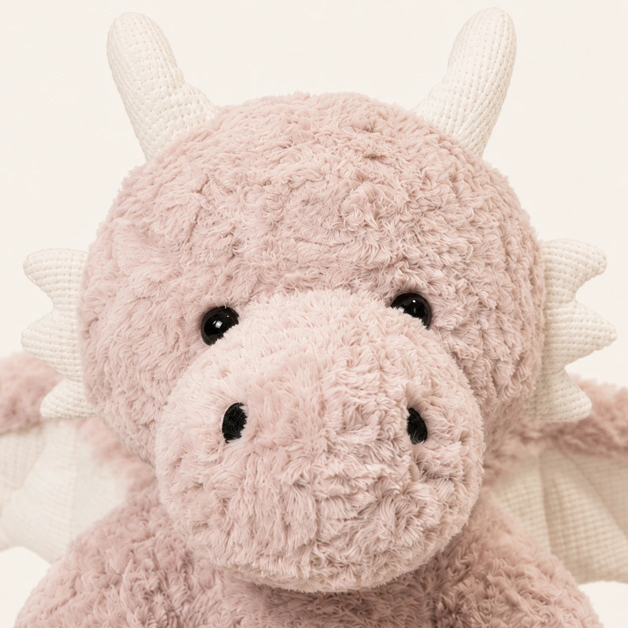 Detail du visage et de la texture de la peluche dragon rose