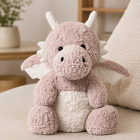 Peluche dragon rose en situation dans un interieur