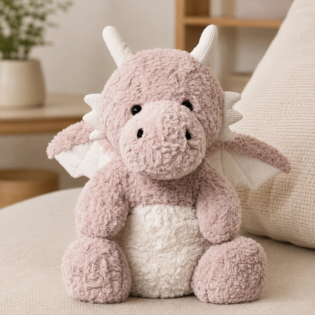 Peluche dragon rose en situation dans un interieur